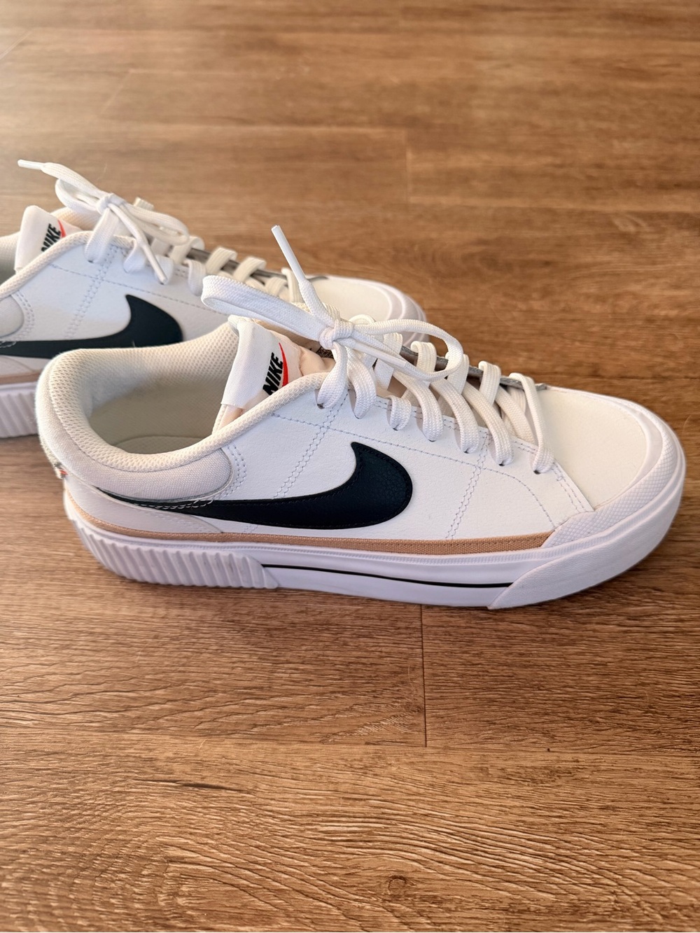 Nike White Low-Top Sneakers with Black Swoosh and Tan Accent